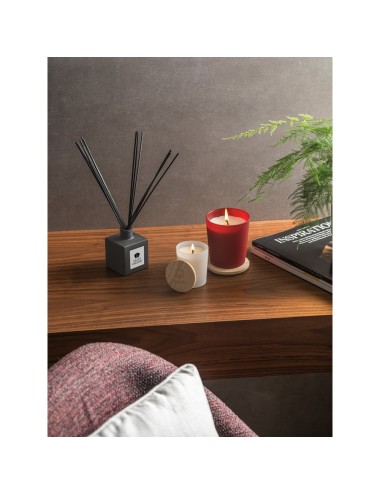 Diffuseur d'arômes en bouteille de verre avec couvercle en bois. Les tiges du diffuseur sont en rotin, une fibre naturelle parfa